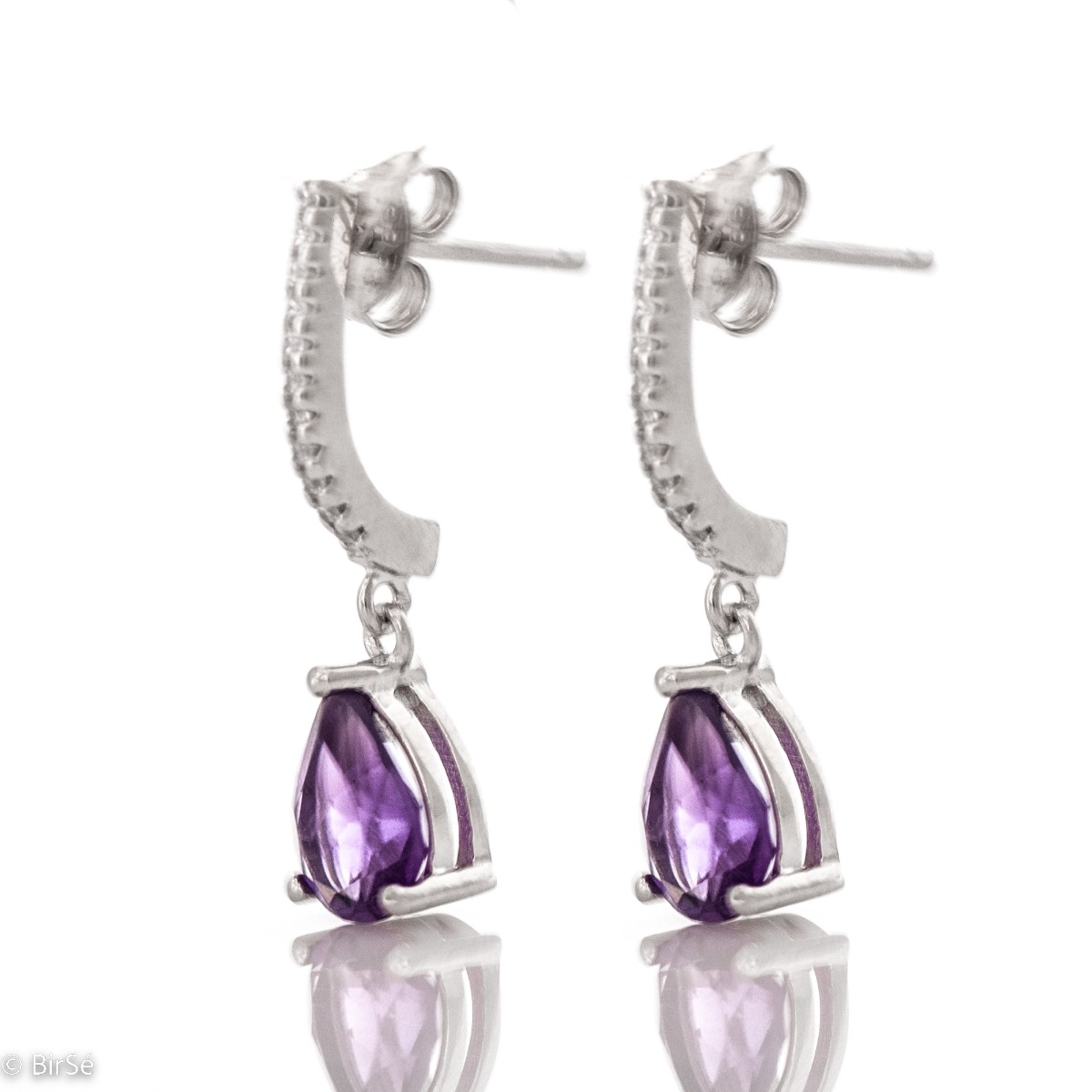 Sophisticated dangling earrings in beautiful rhodium-plated silver. Enigmatic natural amethysts in delicate tandem with sparkling zircons and artfully cast silver.