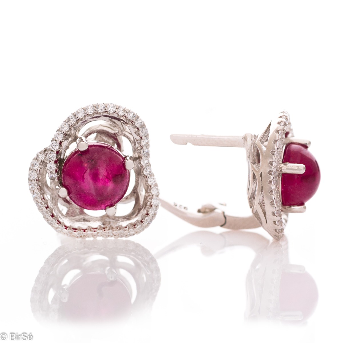 Sophisticated earrings with an exquisite flower-shaped pattern, painstakingly crafted from rhodium-plated silver, captivating ruby ​​and fine cubic zirconias. The set includes a pendant and a ring with the same lovely design.