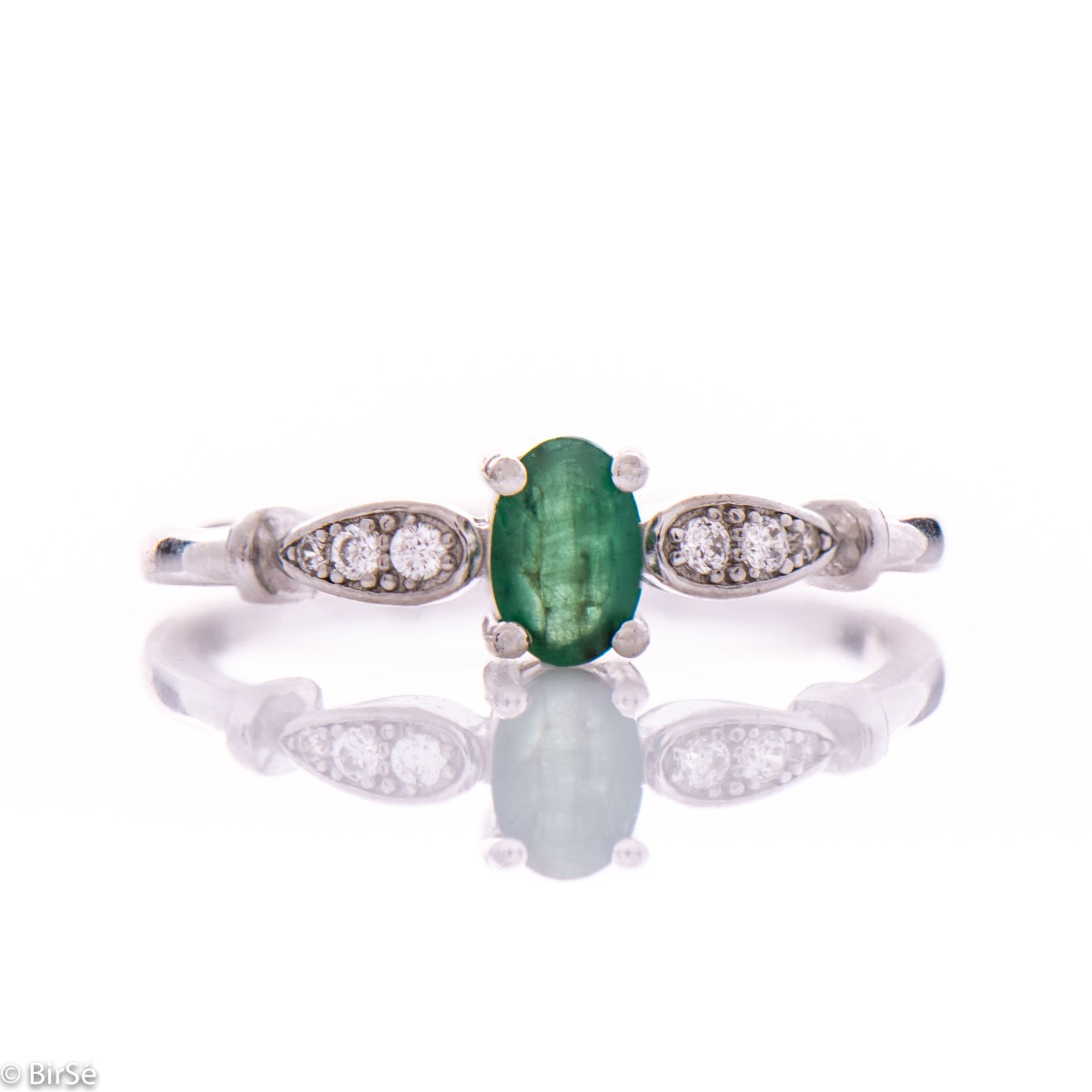 An elegant women's ring with a modern design of the detail and extraordinary craftsmanship entirely of rhodium-plated silver, complemented by the glow of natural emerald stone and fine zircons. In an exclusive sterling silver set with earrings and pendant