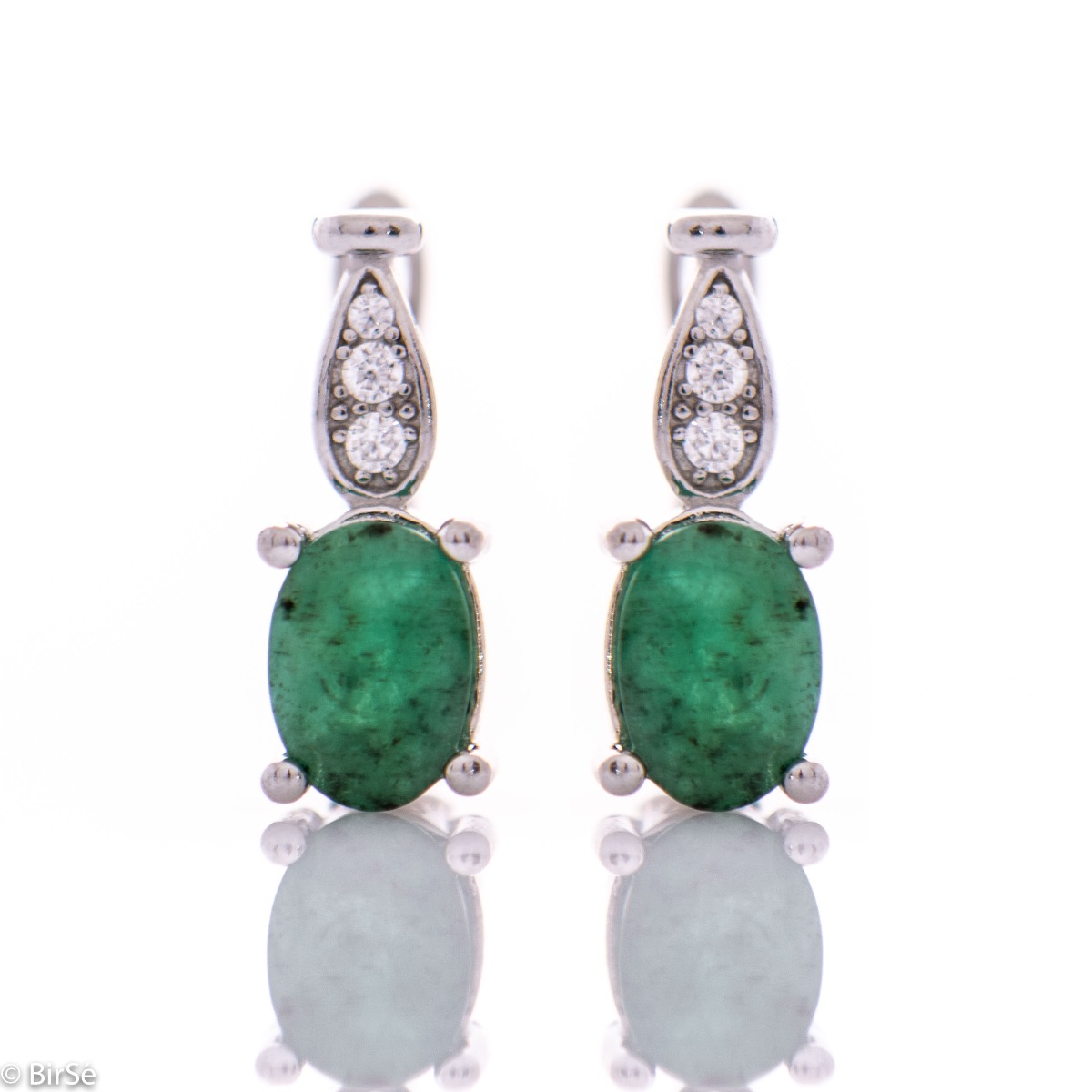 Elegant and radiant ladies earrings with English clasp and delicate curves made entirely of beautiful rhodium silver, combined with the sparkle of natural stone emerald and zircons. In an exclusive sterling silver ring and pendant set.