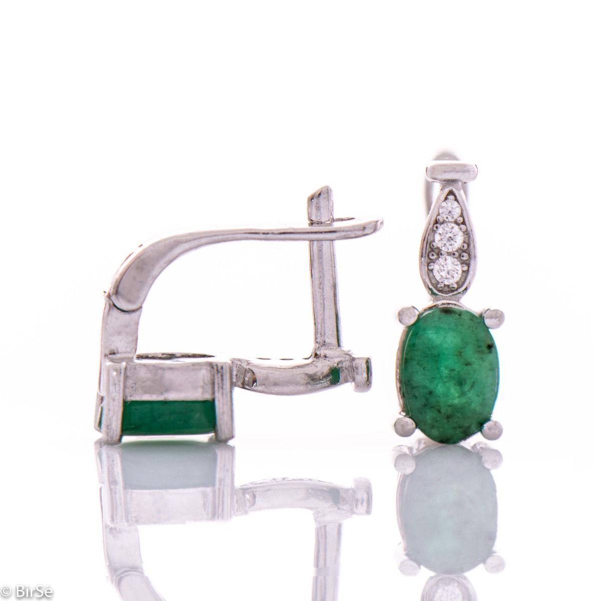 Elegant and radiant ladies earrings with English clasp and delicate curves made entirely of beautiful rhodium silver, combined with the sparkle of natural stone emerald and zircons. In an exclusive sterling silver ring and pendant set.