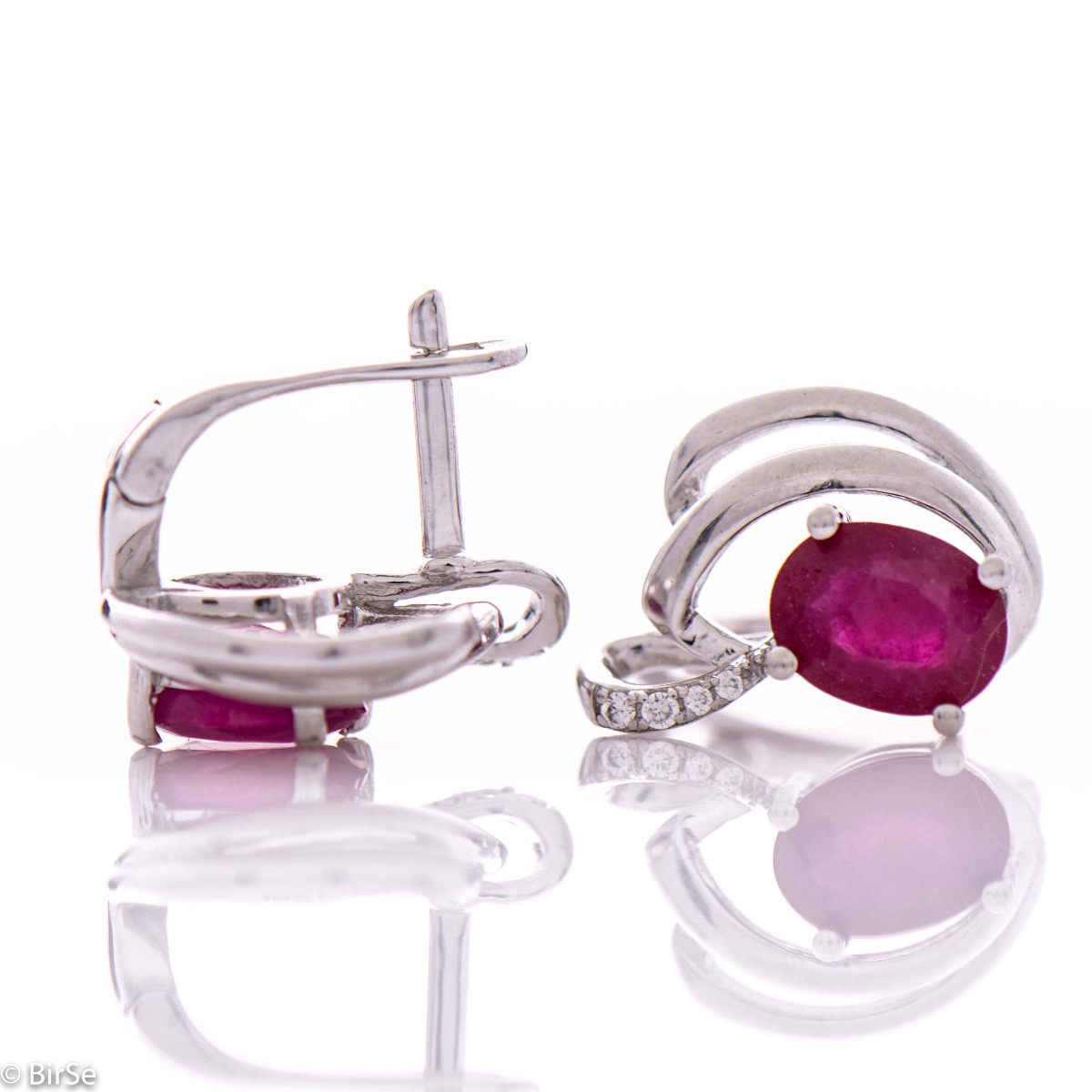 Sophisticated women's earrings with a non-standard and modern design, made entirely of beautiful rhodium-plated silver, complemented by a radiant natural ruby ​​stone and delicate zircons. In an exclusive sterling silver pendant and ring set.