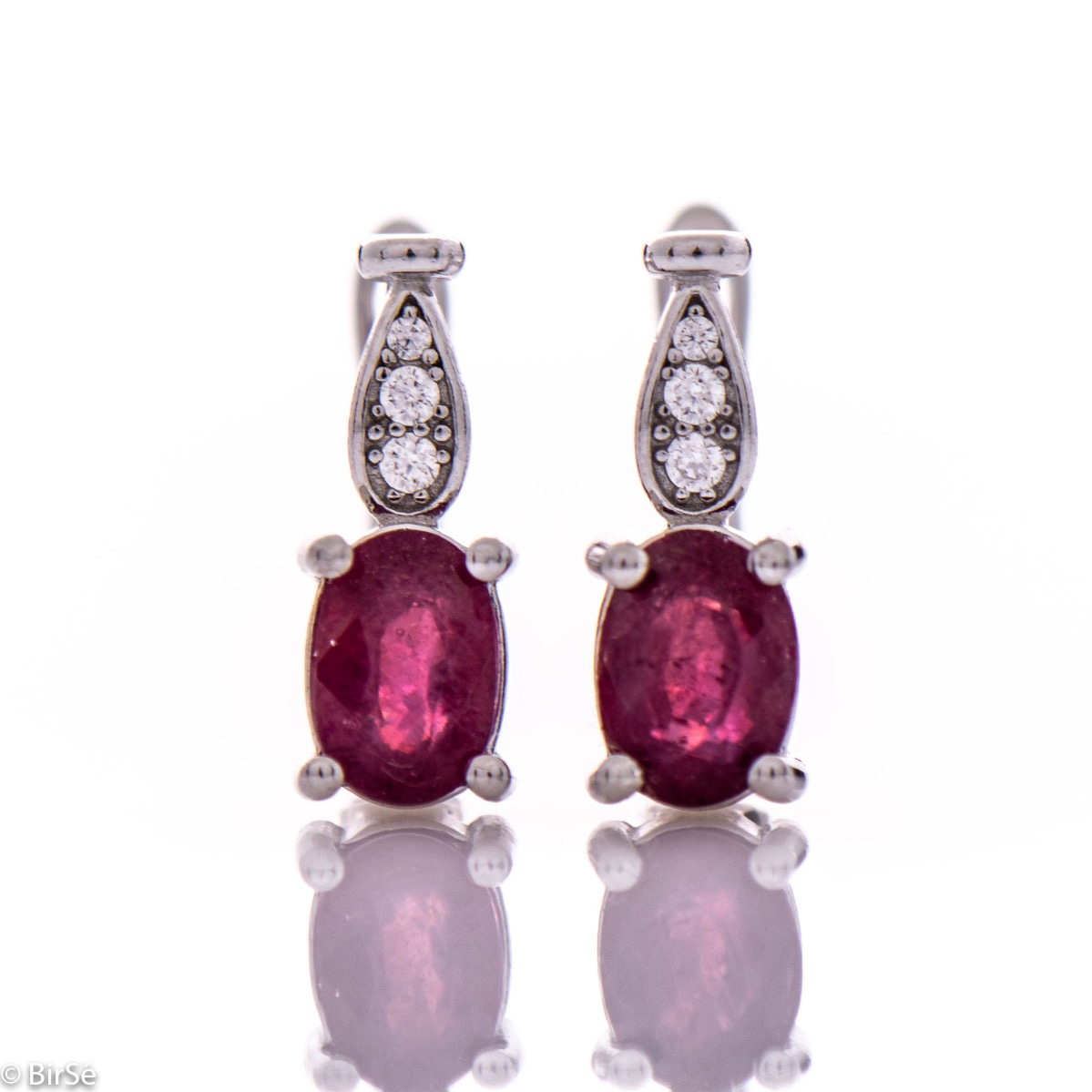 Dazzling women's earrings with English clasp and a delicate combination of a radiant natural ruby, finely crafted in rhodium-plated silver, complemented by beautiful zircons. In an exclusive ring and pendant set.