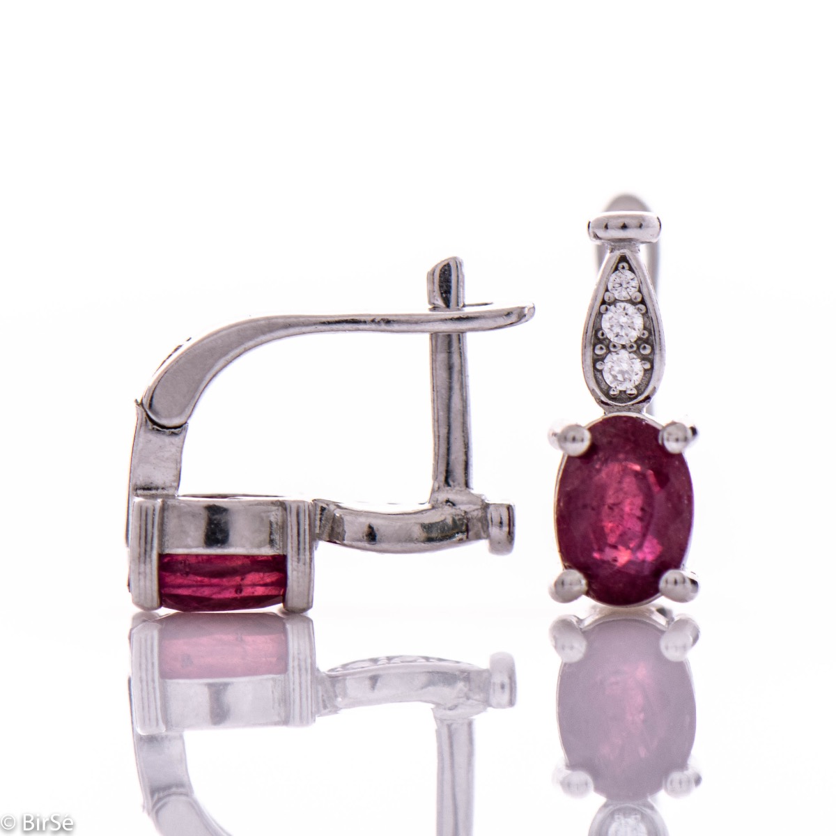 Dazzling women's earrings with English clasp and a delicate combination of a radiant natural ruby, finely crafted in rhodium-plated silver, complemented by beautiful zircons. In an exclusive ring and pendant set.