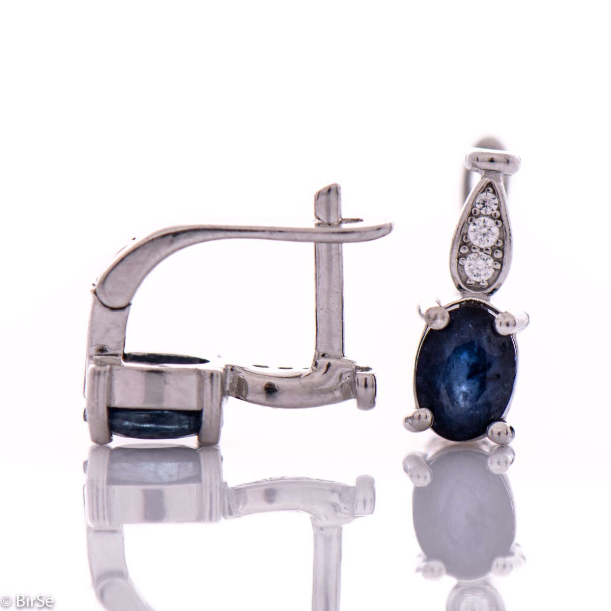 Fine ladies earrings with English clasp and delicate intertwining of radiant natural sapphire with sparkling zircons and exquisite craftsmanship of beautiful rhodium silver. In an exclusive ring and pendant set.