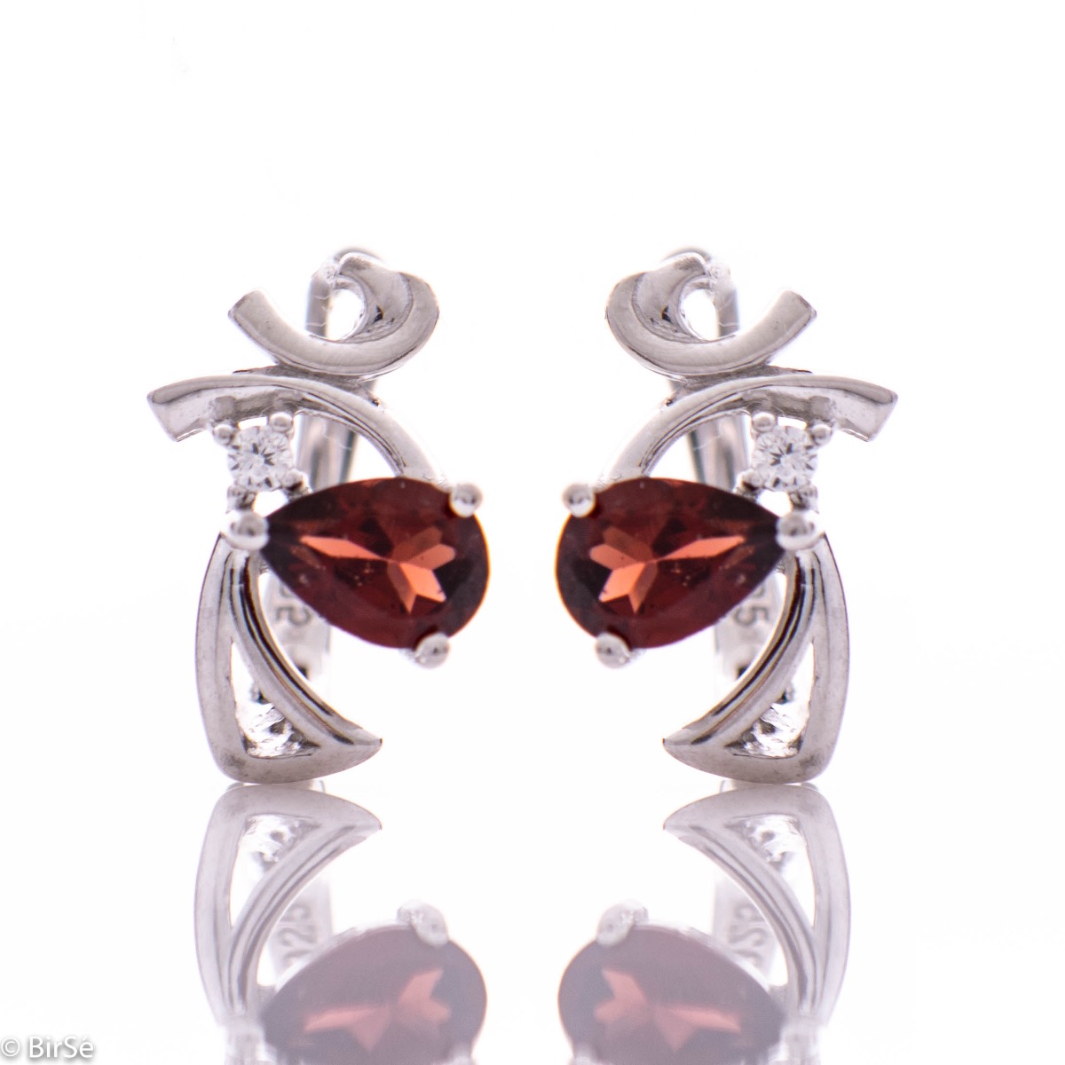 Elegant women's earrings with English clasp and spectacular curves made of beautiful rhodium silver, complemented by the sparkle of natural teardrop garnet and fine zircon. In an exclusive pendant and ring set.