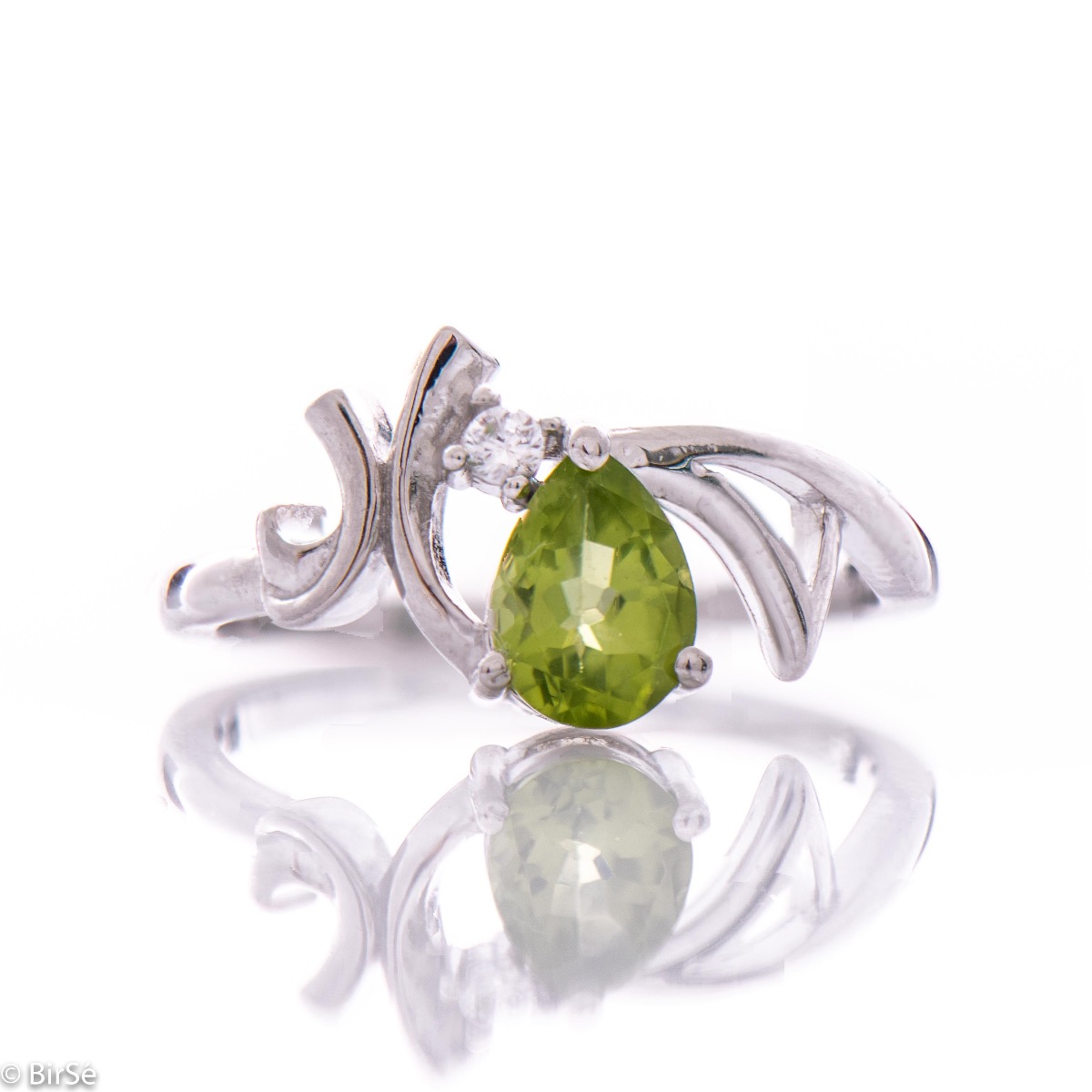 Spectacular and radiant women's ring with a natural peridot stone, in a delicate teardrop shape, complemented by a sparkling zircon and fine workmanship of beautiful rhodium silver. In an exclusive set with earrings and pendant.