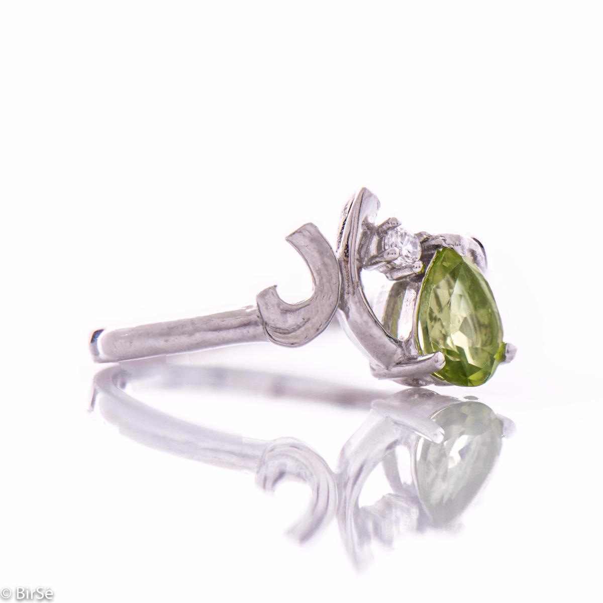 Spectacular and radiant women's ring with a natural peridot stone, in a delicate teardrop shape, complemented by a sparkling zircon and fine workmanship of beautiful rhodium silver. In an exclusive set with earrings and pendant.