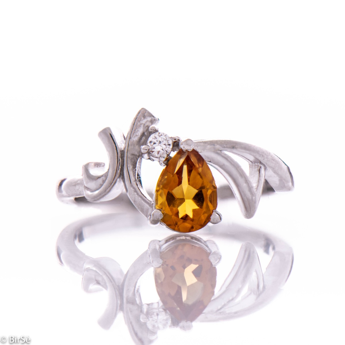 An exquisite women's ring with the color glow of a natural citrine stone, in a delicate teardrop shape, complemented by a sparkling zircon and finely crafted in beautiful rhodium silver. Complete with exquisite earrings.