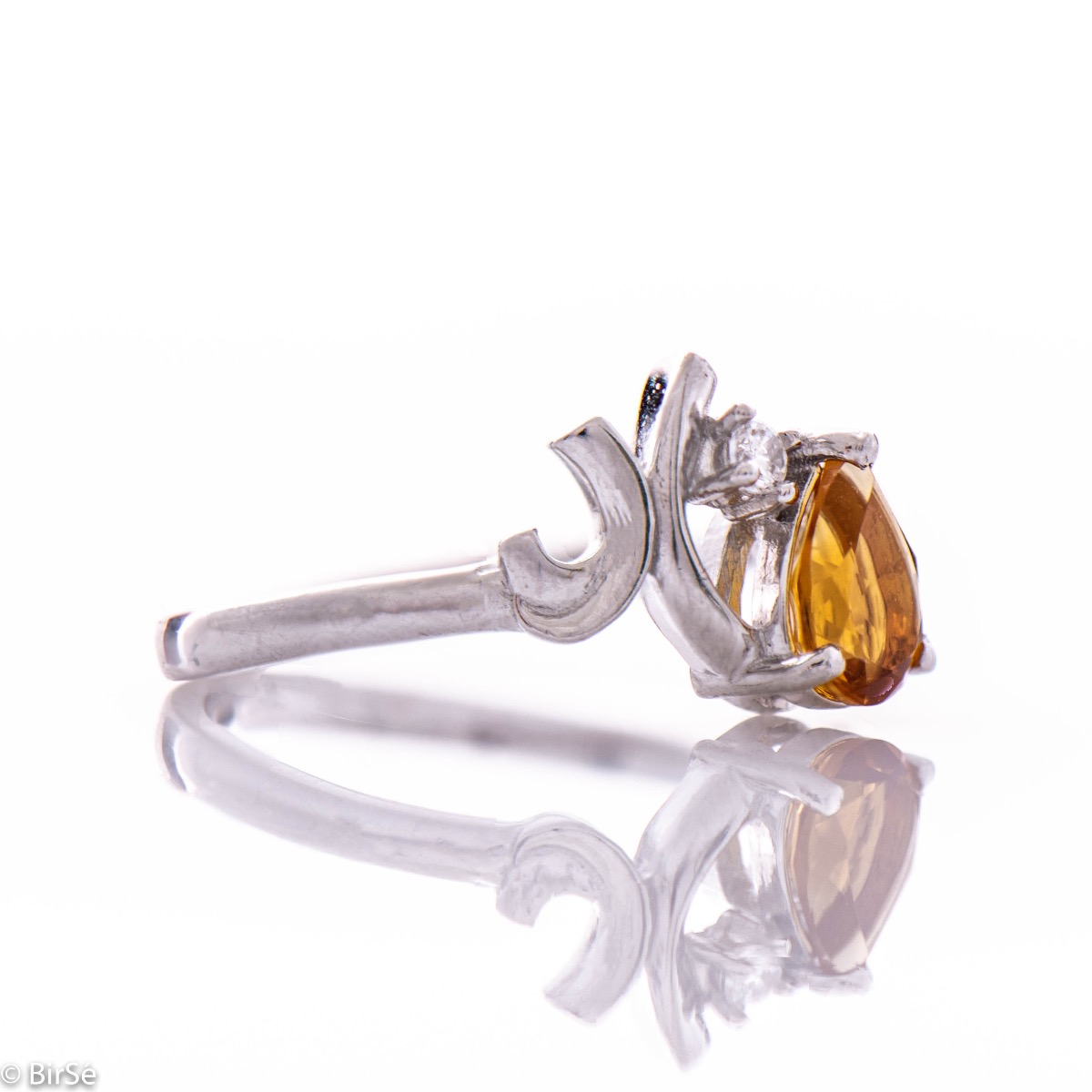 An exquisite women's ring with the color glow of a natural citrine stone, in a delicate teardrop shape, complemented by a sparkling zircon and finely crafted in beautiful rhodium silver. Complete with exquisite earrings.