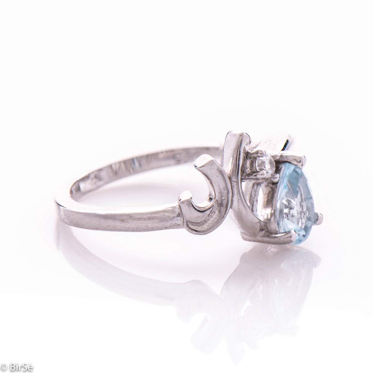 The gentle glow of a natural blue topaz stone, in a beautiful teardrop shape, complemented by a sparkling zircon and finely crafted in exquisite rhodium silver - our new captivating ring for women. In an exclusive set with a pendant and earrings.