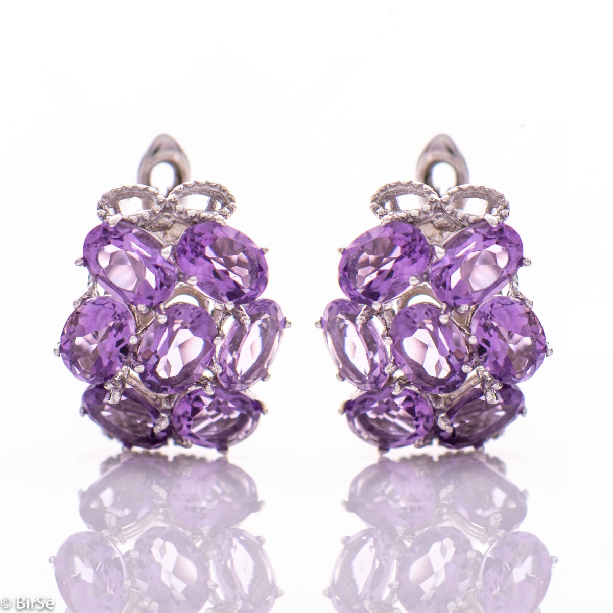 Spectacular earrings with exquisite workmanship entirely of soft rhodium silver combined with the glow of a natural amethyst stone. Part of an exclusive sterling silver three-piece set - with a lovely ring and pendant.