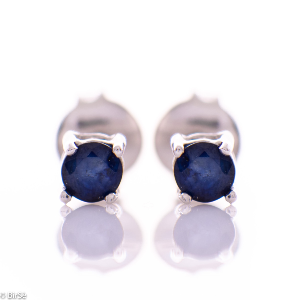 Delicate stud earrings with fine craftsmanship intertwining beautiful rhodium silver and radiant natural sapphire.