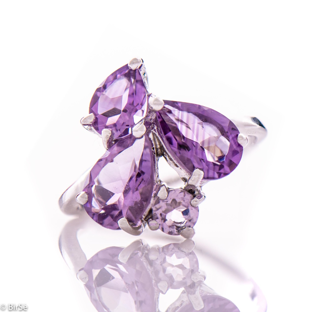 A spectacular combination of rhodium-plated silver and radiant natural amethyst stones in a delicate teardrop shape, forming a beautiful ladies' ring. The broken shape of the ring is suitable for ladies with style. Complete with dangling earrings of the s