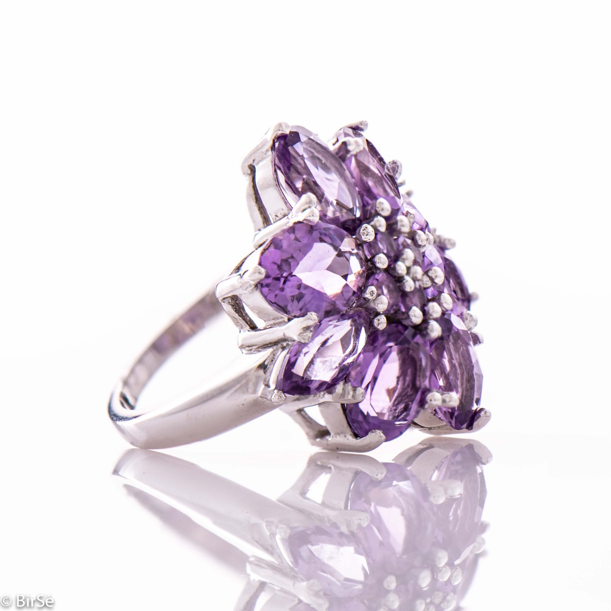 Impressive women's ring in the shape of a beautiful flower of natural and radiant amethyst stones, exquisitely inlaid on soft rhodium silver. The jewelry can be combined with matching earrings and a pendant with natural stones.