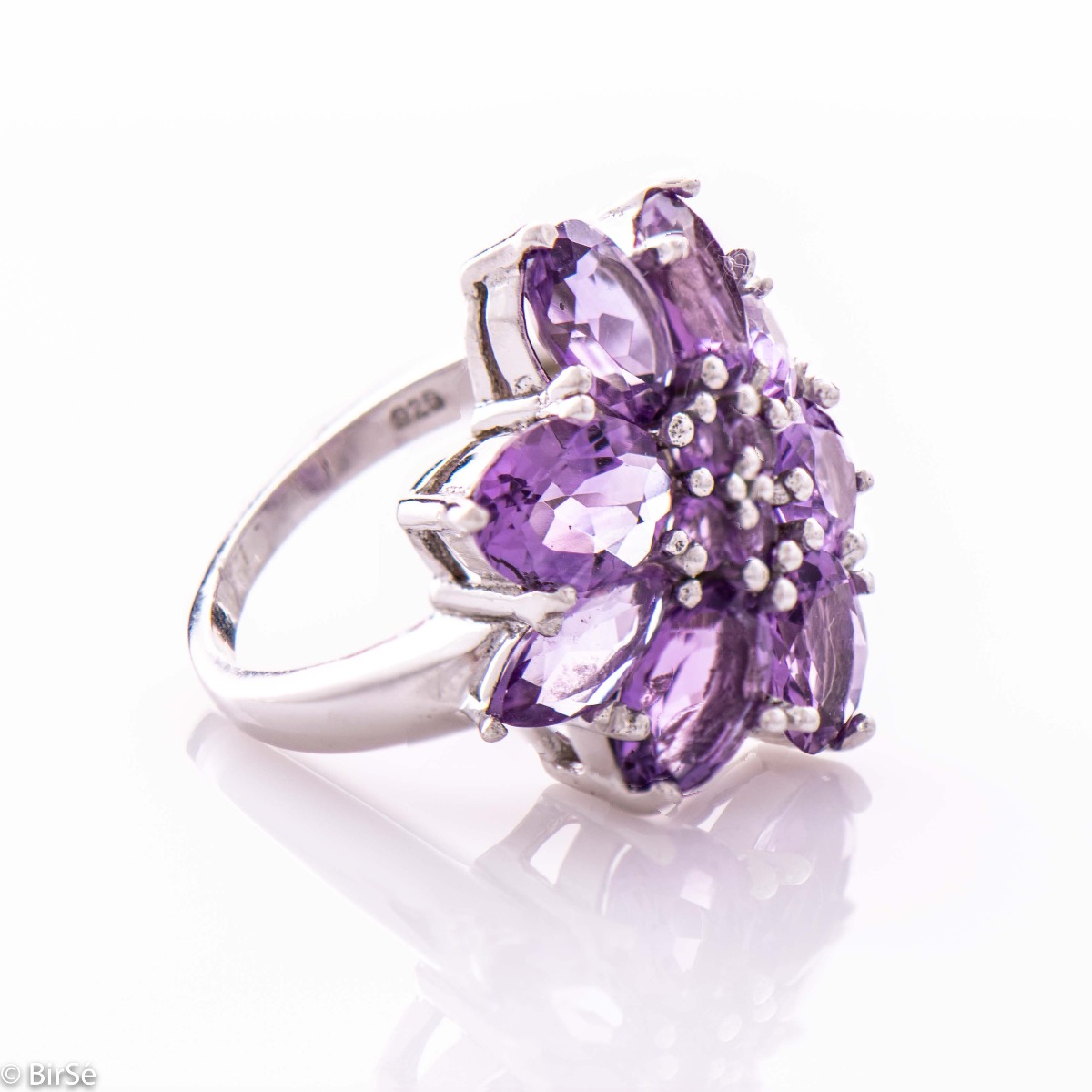 Impressive women's ring in the shape of a beautiful flower of natural and radiant amethyst stones, exquisitely inlaid on soft rhodium silver. The jewelry can be combined with matching earrings and a pendant with natural stones.