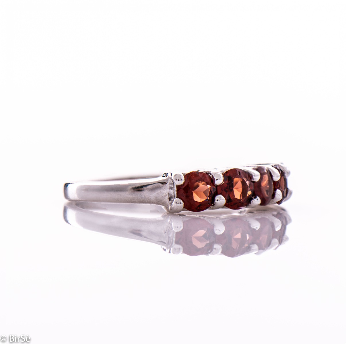 Gentle charm in the form of a lady's ring made of radiant rhodium silver and a row of fine natural garnet stones. A simple yet effective piece of jewelry. It can be combined with a bracelet, earrings and a pendant with garnets. A beautiful gift for any oc