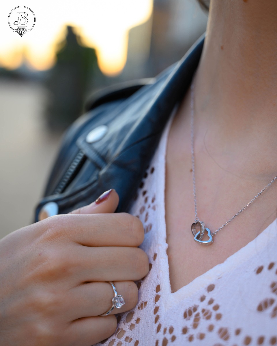 A rhodium-plated silver necklace with a delicate shape of intertwined hearts and a stylish design of side-mounted zircons.