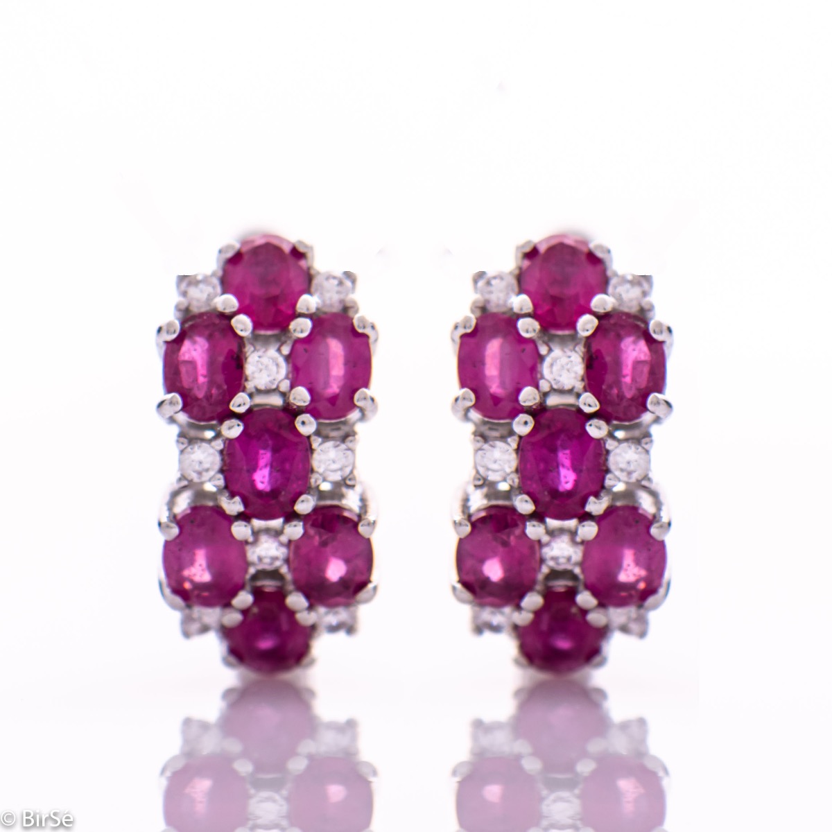 Enchanting pink glow of numerous and fine natural rubies in our new ladies English clasp earrings crafted entirely in rhodium silver and cubic zirconia. In a captivating set with a delicate necklace and ring.