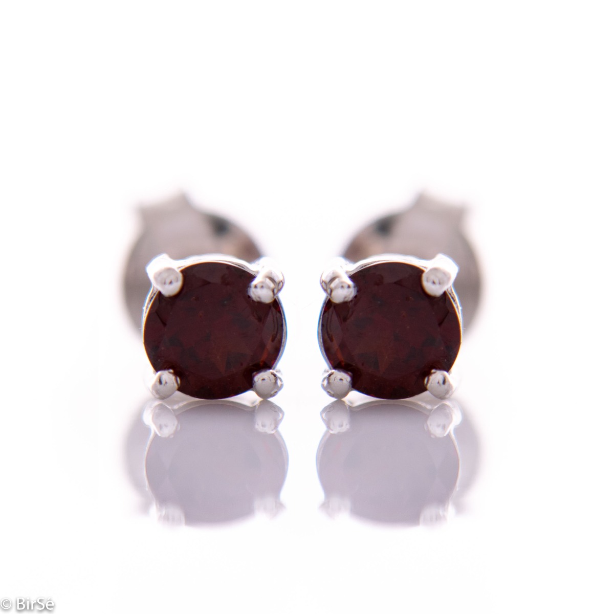 Fine and delicate stud earrings with exquisite workmanship entirely of rhodium-plated silver complemented by the brilliance of a natural garnet stone.