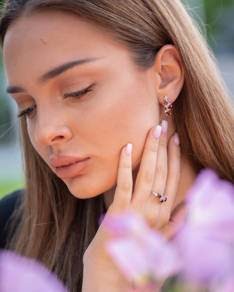 Exclusive ladies' earrings with English clasp and delicate design, combining craftsmanship entirely from rhodium-plated silver, complemented by natural garnets and zircons. They can be combined with a pendant and a ring of the same model.