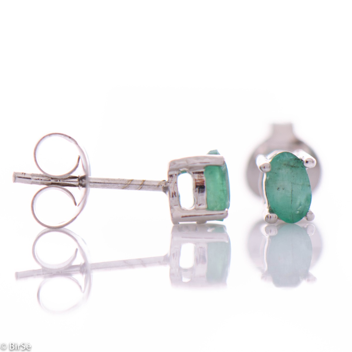 Delicate and spectacular stud earrings of beautiful rhodium silver intertwined with the glow of a natural emerald.