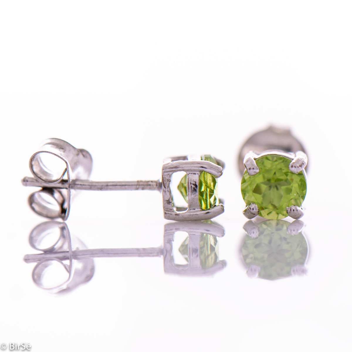 Delicate stud earrings in rhodium-plated silver complemented by the delicate glow of a natural peridot stone.