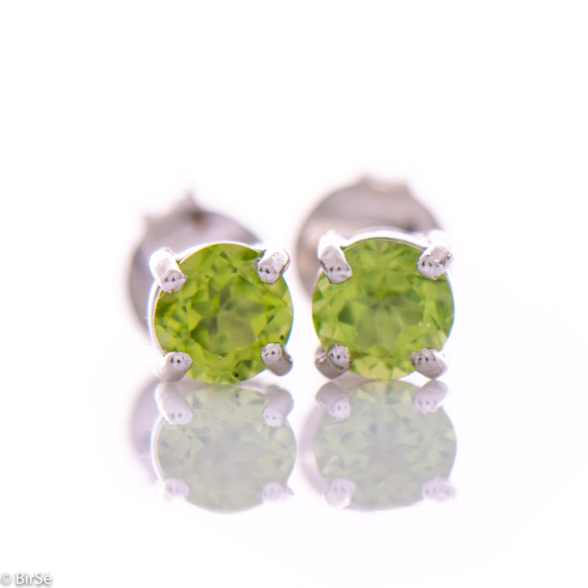 Delicate stud earrings in rhodium-plated silver complemented by the delicate glow of a natural peridot stone.