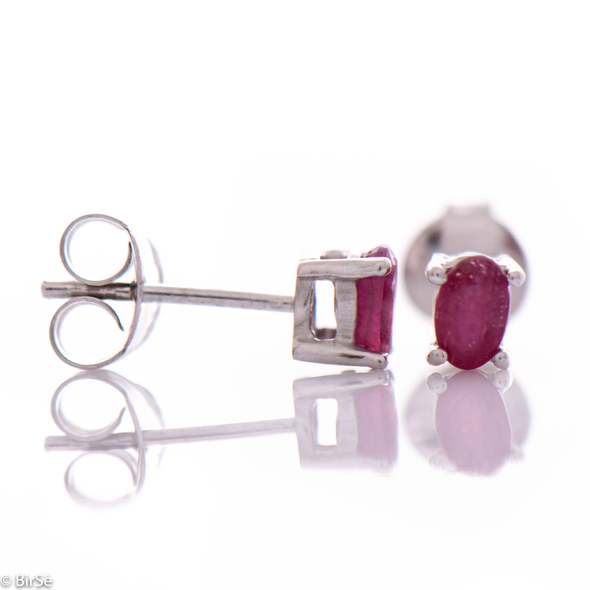 Delicate and spectacular stud earrings of beautiful rhodium silver intertwined with the glow of a natural ruby.