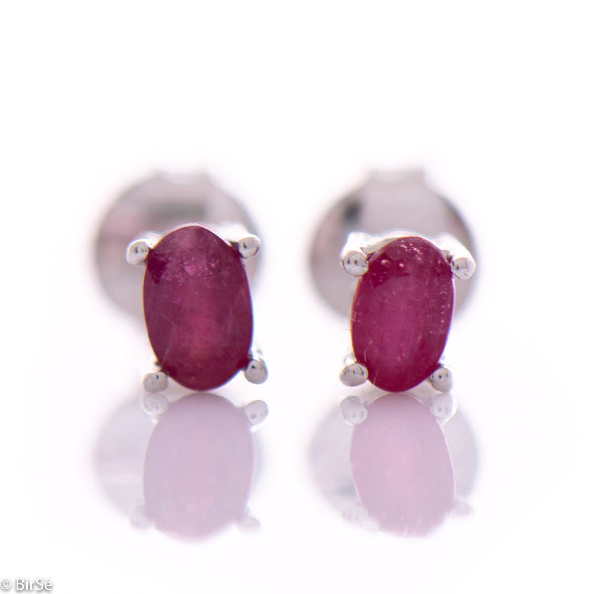 Delicate and spectacular stud earrings of beautiful rhodium silver intertwined with the glow of a natural ruby.