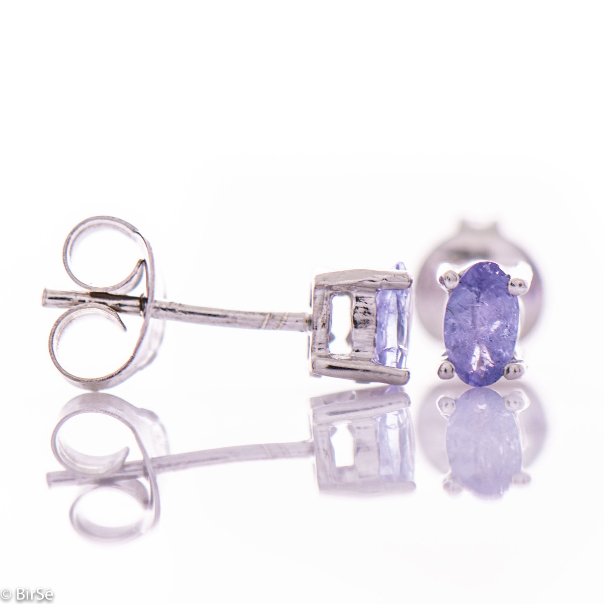 Fine and delicate stud earrings in rhodium silver with the gentle glow of natural tanzanite.