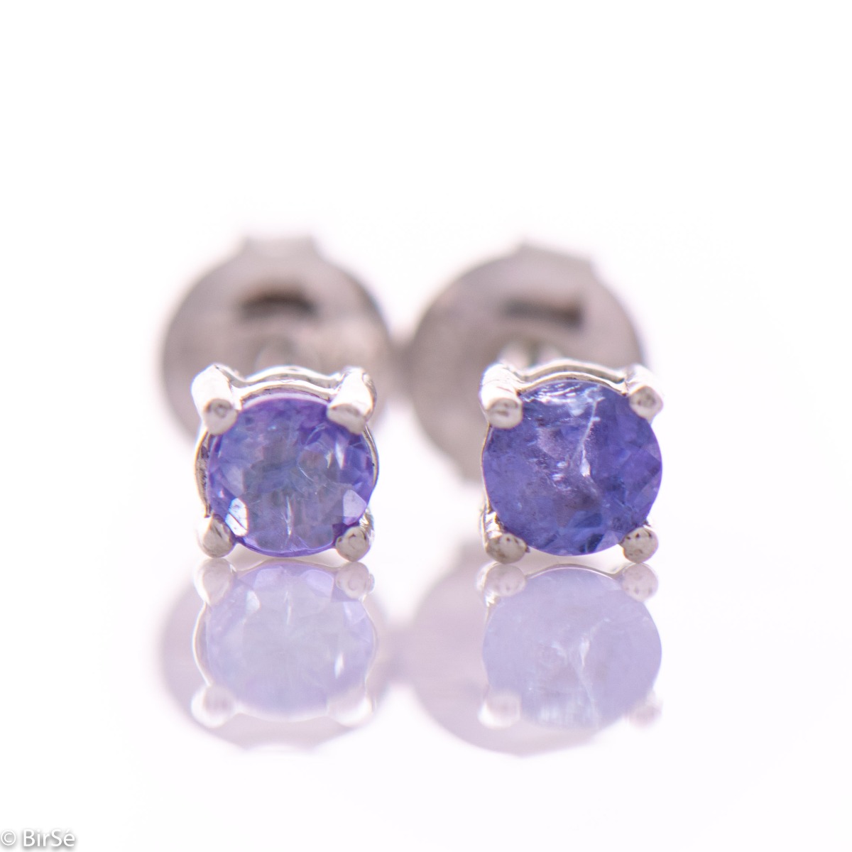 Fine stud earrings combining delicate rhodium silver craftsmanship with the purple glow of natural tanzanite stone.