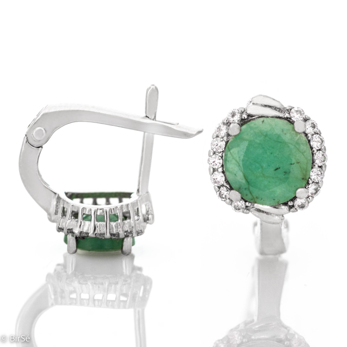 Magnificent earrings in delicate rhodium silver. A round-shaped natural emerald stone lies in the center, surrounded by spectacular zircons.