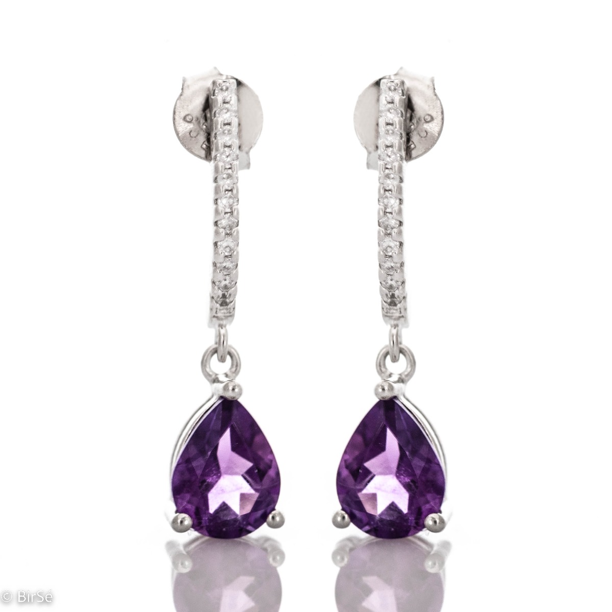 Sophisticated dangling earrings in beautiful rhodium-plated silver. Enigmatic natural amethysts in delicate tandem with sparkling zircons and artfully cast silver.