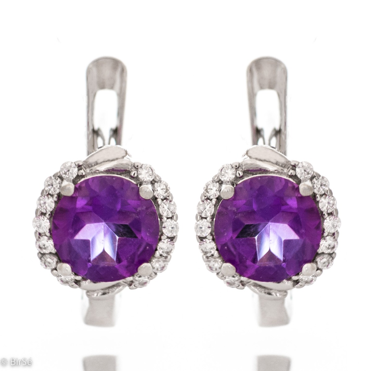 Magnificent earrings in delicate rhodium silver. An enchanted round-shaped amethyst rests in the center, surrounded by spectacular cubic zirconias. A beautiful jewel with a mysterious charm. For ladies who prefer unobtrusive jewelry.