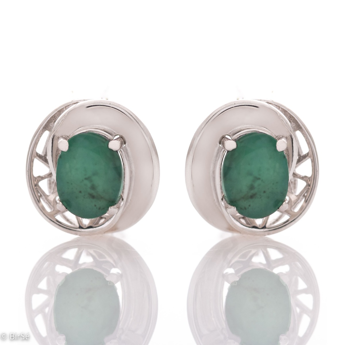 Elegant earrings in rhodium-plated silver and a natural emerald with an oval shape, surrounded by delicate fittings with an exquisite design. Make your look even more spectacular with a pendant and ring from the same collection.