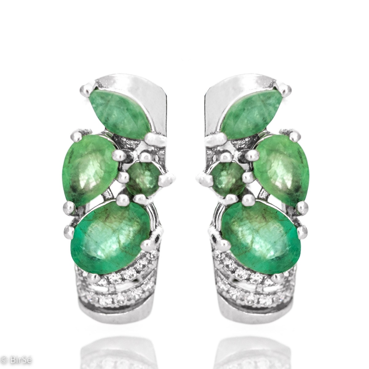 High class elegance is what you deserve. Treat yourself to irresistible earrings made of rhodium-plated silver and amazing natural emeralds, whose stylish design suits every type of face. You can also enjoy a ring and a pendant from the same collection.