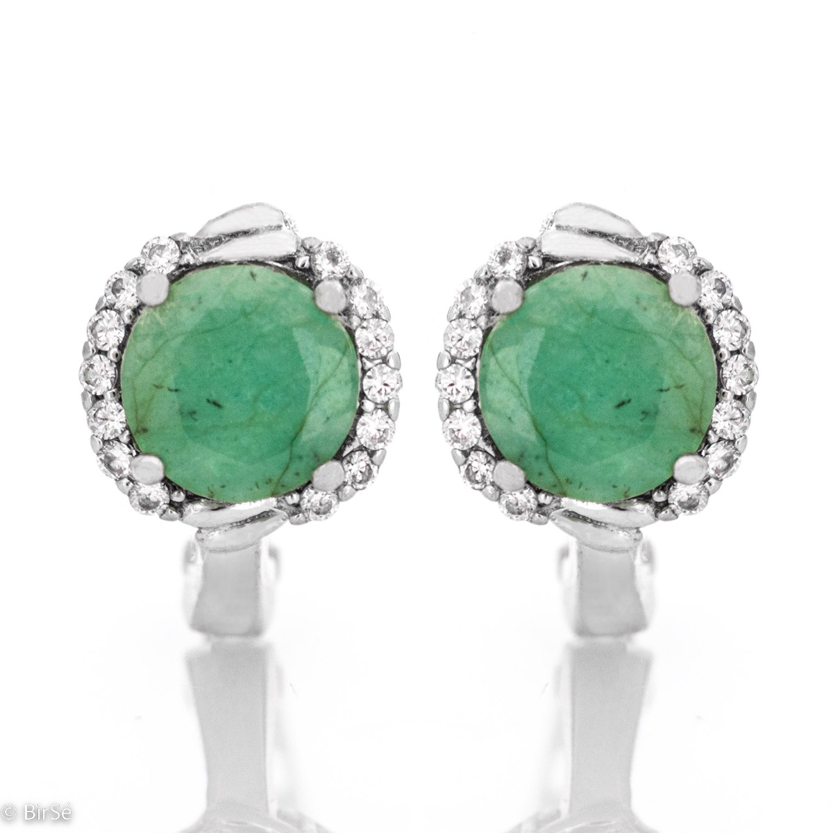 Magnificent earrings in delicate rhodium silver. A round-shaped natural emerald stone lies in the center, surrounded by spectacular zircons.