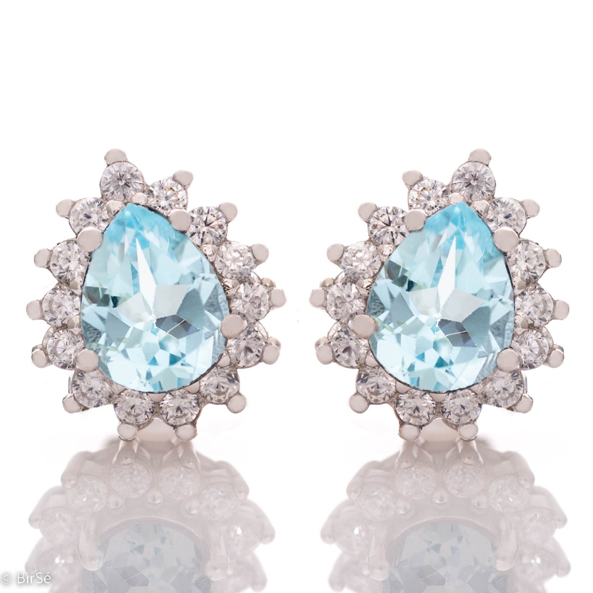 Captivatingly beautiful earrings with natural blue topaz and zircons. The earrings have a delicate drop-shaped design and a pin fastening. In a charming ring and pendant set.