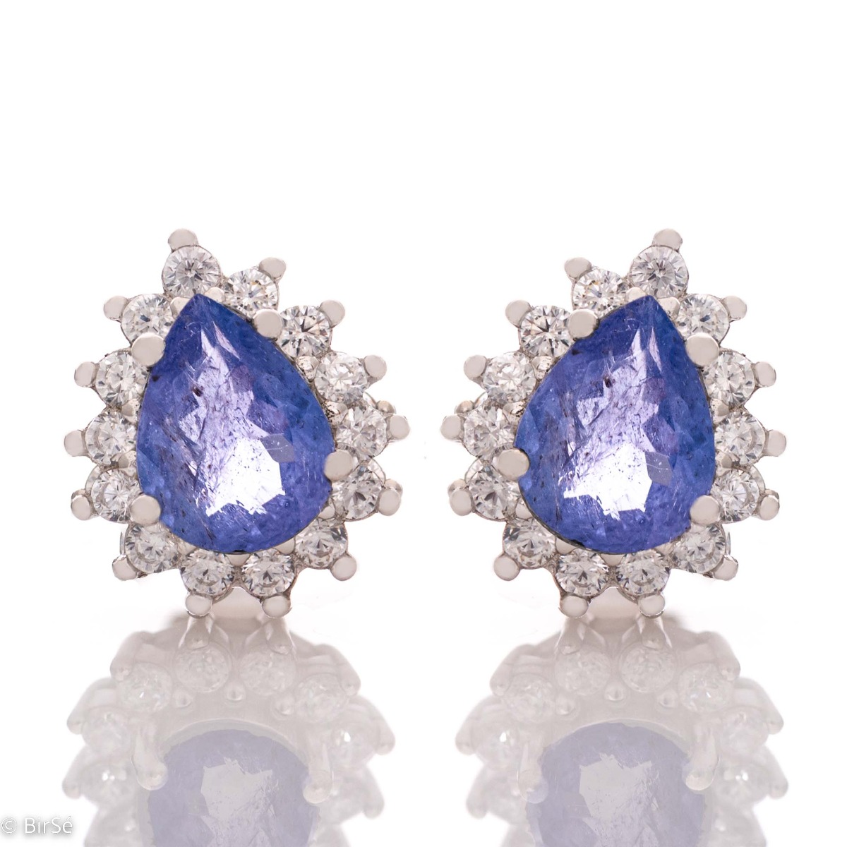 Elegant women's stud earrings with delicate drop-shaped natural tanzanite surrounded by sparkling zircons and exquisitely crafted in beautiful rhodium silver. In a charming ring and pendant set.