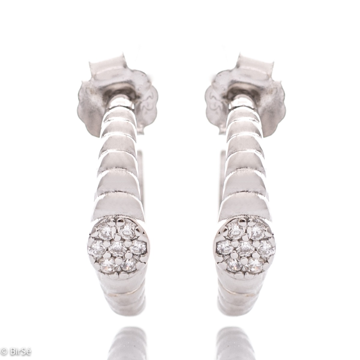 Elegant women's earrings made entirely of fine rhodium-plated silver in the shape of a half-ring. Stylishly decorated with fine zircons, and the fastening is with a pin.