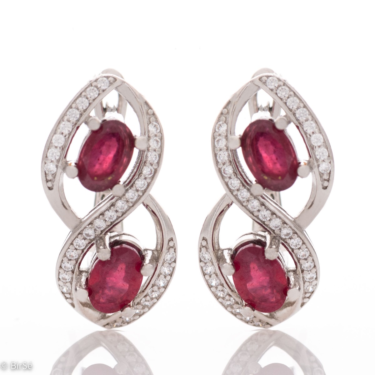 Stunning infinity rhodium silver rhodium-plated sterling silver earrings exquisitely embellished with sparkling cubic zirconias encircling royal rubies. Complete with a ring of the same design.