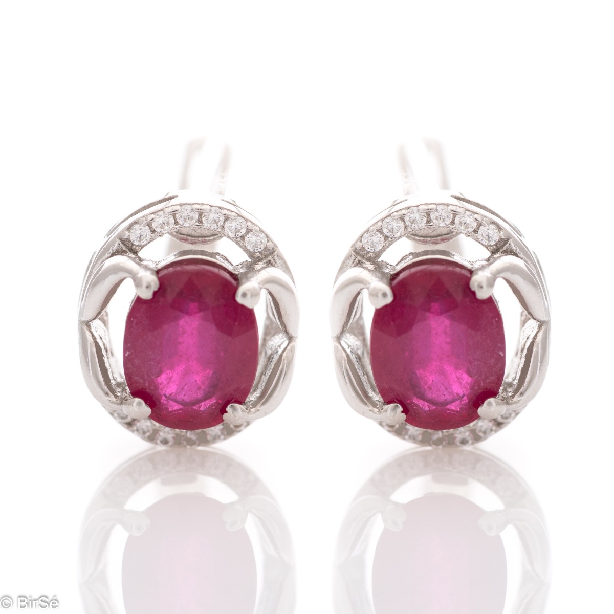 A royal vision - elegant silver earrings with a delicate design. Stylish composition made of a fine combination of rhodium-plated silver with sparkling zircon stones and an exquisite ruby. In a lovely set with a ring from the model.