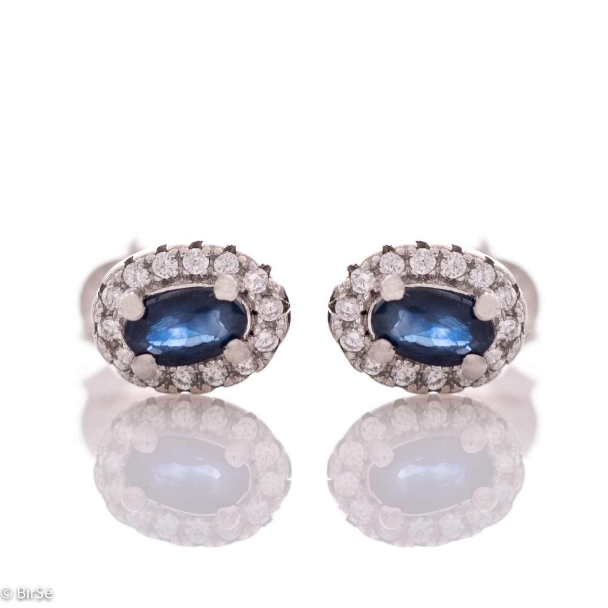 Stylish women's earrings with an elegantly shaped pattern of rhodium-plated silver and a natural sapphire stone, beautifully surrounded by dazzling zircons.