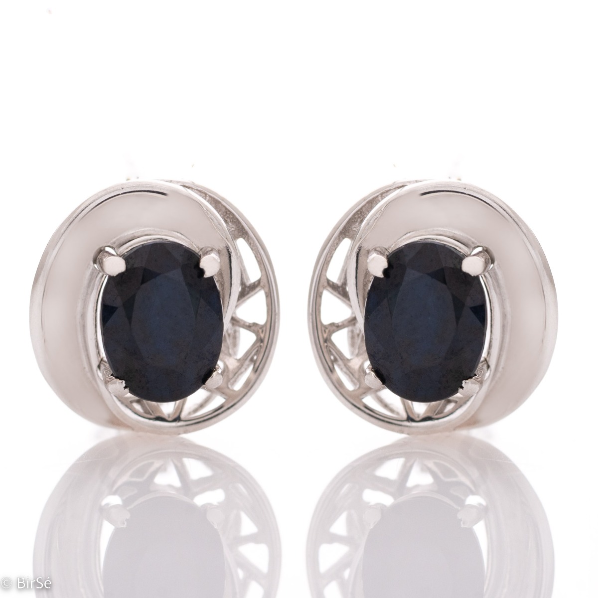 Elegant rhodium-plated silver and natural sapphire earrings with an oval shape, surrounded by delicate fittings with an exquisite design. Make your look even more spectacular with a pendant and ring from the same collection.