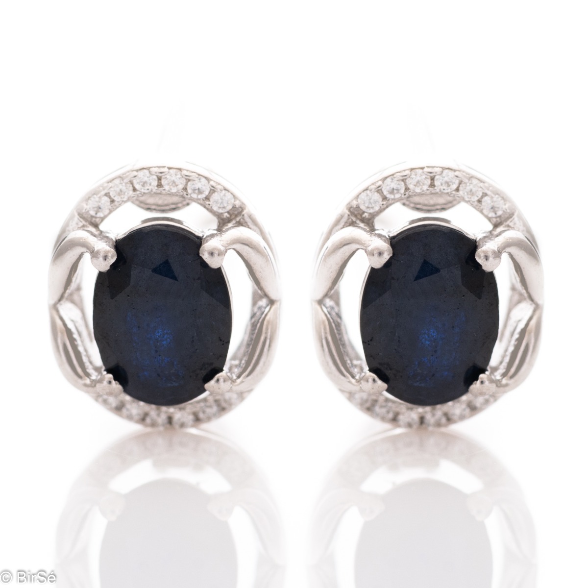 A royal vision - elegant silver earrings with a delicate design. Stylish composition made of a fine combination of rhodium-plated silver with sparkling zircon stones and exquisite sapphire. In a lovely ring and pendant set from the model.