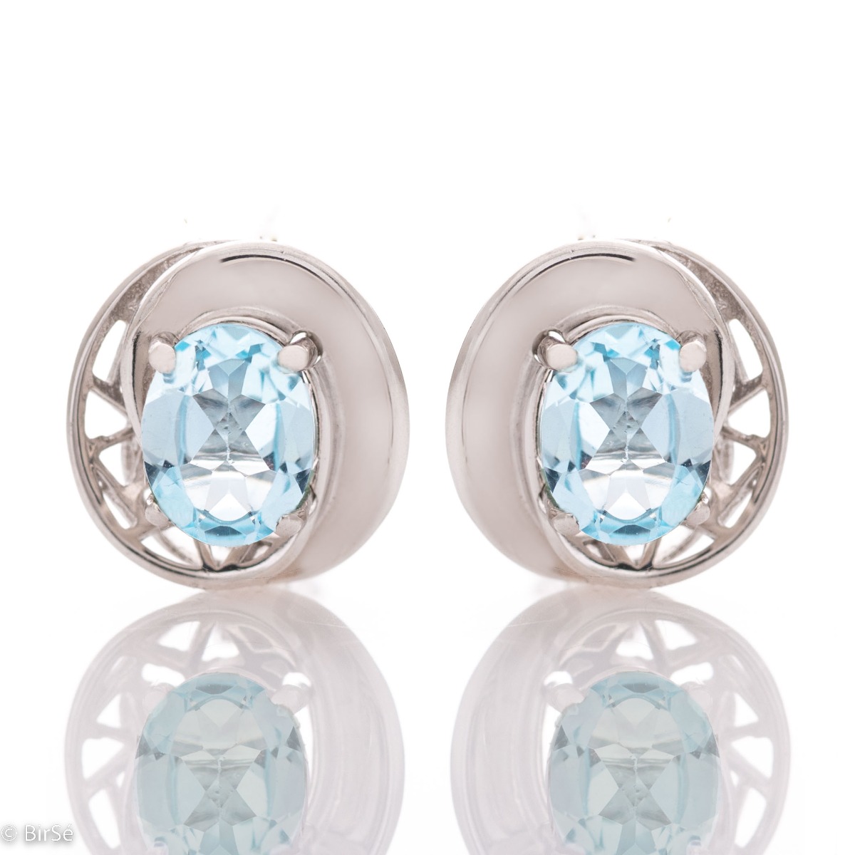 Dazzling rhodium-plated sterling silver and natural blue topaz earrings in an oval shape, encased in delicate hardware with an exquisite design. Make your look even more spectacular with a pendant and ring from the same collection.