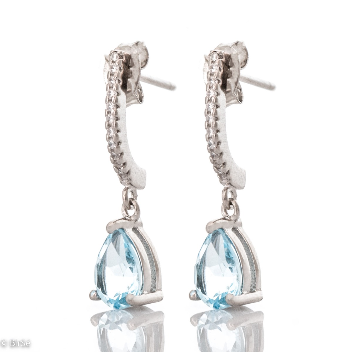 Exquisite earrings with a beautiful and stylish design - made of rhodium silver in combination with natural blue topaz and sparkling zircons. Complete your jewelry collection with these exquisite azure earrings.