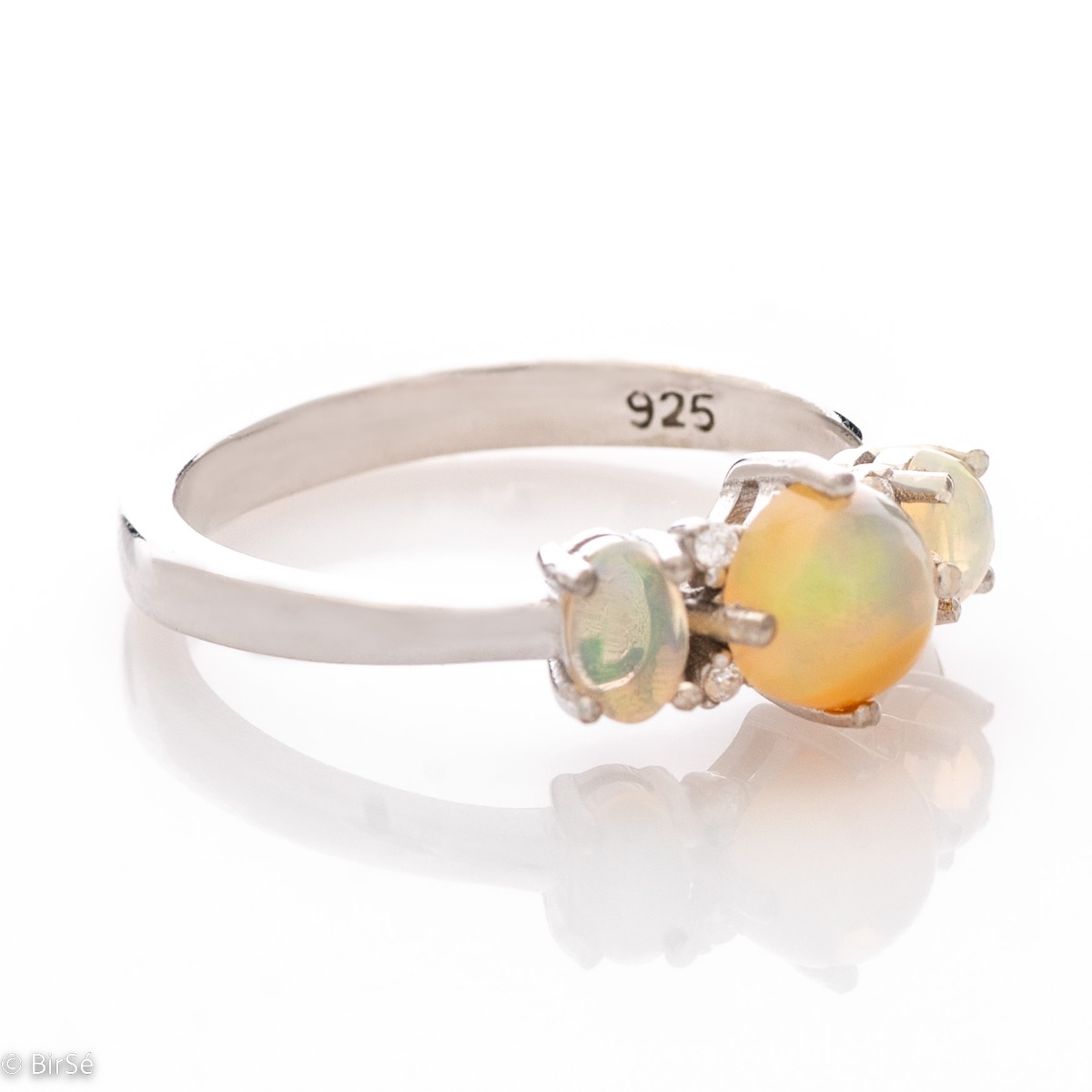 Exquisitely crafted women's ring made entirely of rhodium-plated silver, gently surrounding natural opal stones and fine zircons. Part of a charming set of dangling earrings and a pendant, with a charming design.