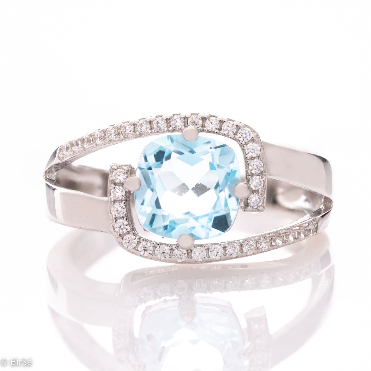 Delicately elegant women's ring with a sophisticated look and fine detailing. Stylish composition made from a sophisticated combination of rhodium-plated silver with spectacular blue topaz and sparkling zircon stones.